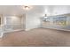 Spacious loft area with neutral carpeting, fan, and bright natural light from the windows at 10993 Ladyburn Ct, Las Vegas, NV 89141