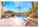 Inviting backyard pool with rock waterfall feature, outdoor kitchen, and lush landscaping offers a private oasis at 10993 Ladyburn Ct, Las Vegas, NV 89141