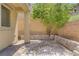 Private backyard featuring a stone-paved area, decorative plants and retaining wall at 11247 Villa Trentino Ct, Las Vegas, NV 89141