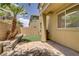 Cozy backyard featuring a small grassy area, paved patio, desert plants and BBQ at 11247 Villa Trentino Ct, Las Vegas, NV 89141
