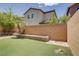 Well-maintained backyard featuring artificial turf, a mature palm tree, and a low brick retaining wall at 11247 Villa Trentino Ct, Las Vegas, NV 89141