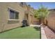 Backyard area with artificial turf, palm tree, and BBQ; great for entertaining at 11247 Villa Trentino Ct, Las Vegas, NV 89141
