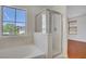 Bathroom featuring a tub with a large window and a glass-enclosed shower at 11247 Villa Trentino Ct, Las Vegas, NV 89141