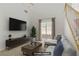 Inviting, virtually staged living room with large screen TV and sliding glass doors at 11247 Villa Trentino Ct, Las Vegas, NV 89141
