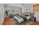 Bright, virtually staged bedroom with a plush bed, two chairs, and light-filled windows at 11247 Villa Trentino Ct, Las Vegas, NV 89141