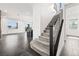 Bright foyer featuring dark tile flooring, a staircase with metal railing, and an open-concept living area at 11800 Black Canary Ave, Las Vegas, NV 89138