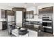 Well-appointed kitchen features stainless steel appliances, island with bar stools at 11800 Black Canary Ave, Las Vegas, NV 89138