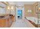 Bright bathroom featuring a vanity, soaking tub, and open doorway to the bedroom at 125 E Harmon Ave # 2814/2816, Las Vegas, NV 89109