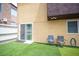 Inviting backyard featuring artificial grass, patio chairs, and a sliding glass door, creating a cozy outdoor retreat at 1511 Living Desert Dr # C, Las Vegas, NV 89119