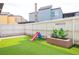 A charming backyard with artificial grass, a slide, and a decorative planter box, perfect for outdoor play and relaxation at 1511 Living Desert Dr # C, Las Vegas, NV 89119