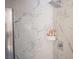 Bathroom shower with a built-in shelving unit against beautiful marble-patterned walls at 1511 Living Desert Dr # C, Las Vegas, NV 89119
