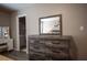 Spacious main bedroom features an ensuite bath and a large wood dresser with a mirror at 1511 Living Desert Dr # C, Las Vegas, NV 89119
