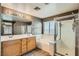 Primary bath featuring double sinks, garden tub, and glass shower at 1733 Gentle Brook St, North Las Vegas, NV 89084