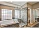 Primary bathroom featuring a tub, glass shower, and a window at 1742 Sand Storm Dr, Henderson, NV 89074