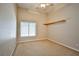 Neutral carpeted bedroom features a ceiling fan, window with blinds, and a small shelf at 1742 Sand Storm Dr, Henderson, NV 89074
