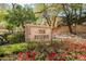Inviting community entrance sign amidst lush landscaping and vibrant red flowers at 1742 Sand Storm Dr, Henderson, NV 89074