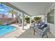 Covered patio with furniture, slide into the pool, and a beautiful backyard at 2011 Mountain Sunset Ave, North Las Vegas, NV 89031