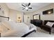 Bright bedroom with a ceiling fan, TV, black dresser, and a comfy chair with a bunny pillow at 2050 W Warm Springs Rd # 2822, Henderson, NV 89014