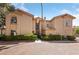 Exterior view of a well-maintained two-story condo building with manicured bushes at 2050 W Warm Springs Rd # 2822, Henderson, NV 89014
