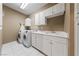 Efficient laundry room with white cabinets, a countertop, a sink, and a modern washer and dryer at 2050 W Warm Springs Rd # 2822, Henderson, NV 89014
