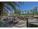 Outdoor kitchen with stone surround, built-in BBQ, picnic tables, and seating for relaxed outdoor dining at 2050 W Warm Springs Rd # 2822, Henderson, NV 89014