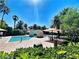 Tranquil pool area features a bridge, lounge chairs, umbrellas, and lush landscaping, perfect for relaxation at 2050 W Warm Springs Rd # 2822, Henderson, NV 89014