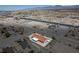 An aerial view showcases the home near a highway in a desert landscape with sparse vegetation at 2090 S Ambush St, Pahrump, NV 89048