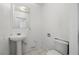Small bathroom features a pedestal sink, tile flooring, and a standard toilet at 2090 S Ambush St, Pahrump, NV 89048