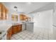Bright kitchen featuring wooden cabinets, white appliances, and tile flooring at 2090 S Ambush St, Pahrump, NV 89048