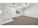 Bright living room featuring neutral carpet, white walls, and a decorative front door at 2090 S Ambush St, Pahrump, NV 89048