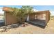 Exterior shot of the covered patio showcasing concrete flooring, access doors, and landscaping at 2090 S Ambush St, Pahrump, NV 89048