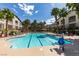 Beautiful community pool surrounded by palm trees and lounge chairs on a sunny day at 2305 W Horizon Ridge Pkwy # 3713, Henderson, NV 89052
