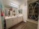 Bright bathroom with double sinks and lots of storage in white cabinets and hardwood floors at 2559 Purple Heather Pl, Henderson, NV 89052