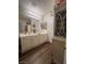 Bright bathroom with dual sinks, white cabinetry and decorative storage at 2559 Purple Heather Pl, Henderson, NV 89052