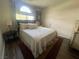 Cozy bedroom featuring a large window, neutral colored walls, and hardwood floors at 2559 Purple Heather Pl, Henderson, NV 89052