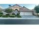 Charming single-story home featuring a lush front yard, stone accents, and a two-car garage at 2559 Purple Heather Pl, Henderson, NV 89052