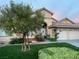 Charming single-story home featuring a lush front yard with beautiful roses and a two-car garage at 2559 Purple Heather Pl, Henderson, NV 89052