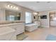 Bright bathroom with dual sinks, a standalone soaking tub and a tiled glass shower at 26 Olympia Outlook Dr, Las Vegas, NV 89141