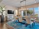 Stylish dining area with modern chandelier, sleek furniture, and a bright view to the yard at 26 Olympia Outlook Dr, Las Vegas, NV 89141