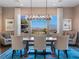 Elegant dining room featuring a modern chandelier, mountain views, and stylish blue rug at 26 Olympia Outlook Dr, Las Vegas, NV 89141