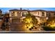 Grand two-story home with stone accents, dual garages, and professionally lit landscaping at 26 Olympia Outlook Dr, Las Vegas, NV 89141