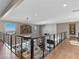 Second-floor hallway with hardwood floors and stylish decor overlooks the open-concept living area at 26 Olympia Outlook Dr, Las Vegas, NV 89141