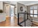 Bright hallway featuring hardwood floors, modern railing, and stylish decor, creating an inviting transition between spaces at 26 Olympia Outlook Dr, Las Vegas, NV 89141