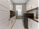 Bright laundry room featuring modern appliances and white cabinets with stylish mosaic backsplash at 26 Olympia Outlook Dr, Las Vegas, NV 89141