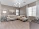 Relaxing living room featuring modern lighting, a plush sectional sofa, and large windows with sheer curtains at 26 Olympia Outlook Dr, Las Vegas, NV 89141