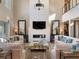 Bright living room with a two-story ceiling, modern fireplace and views from large windows at 26 Olympia Outlook Dr, Las Vegas, NV 89141