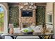 Inviting outdoor dining area with a brick fireplace, lush greenery, and stylish decor at 26 Olympia Outlook Dr, Las Vegas, NV 89141