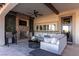 Cozy outdoor living area with a fireplace, comfortable seating, and a ceiling fan for relaxation at 26 Olympia Outlook Dr, Las Vegas, NV 89141