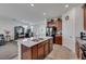 Open-concept kitchen with dark wood cabinets, stainless steel appliances, granite countertops, and an island overlooking the dining area at 2849 Mincio St, Henderson, NV 89044