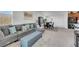 Spacious living room featuring a large sectional sofa, access to the backyard, and seamless connection to the kitchen and dining area at 2849 Mincio St, Henderson, NV 89044